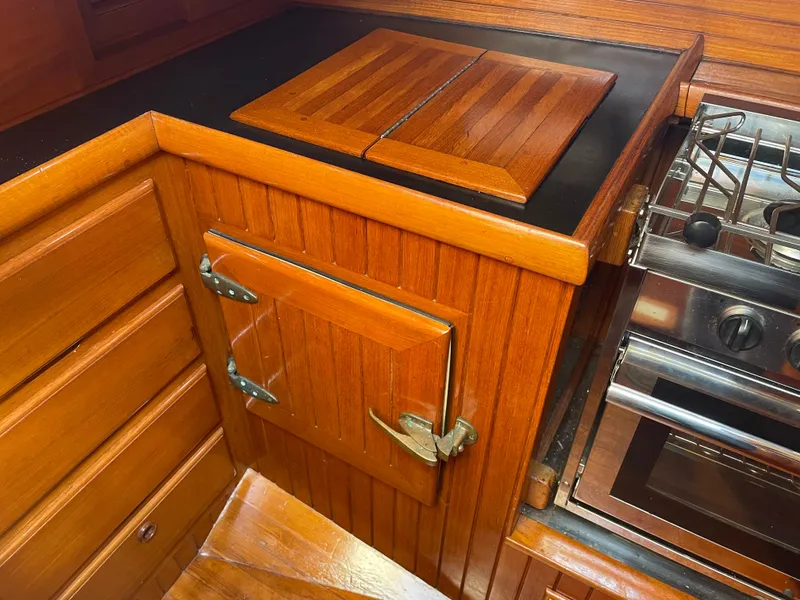 Slide: The Image of Wooden galley interior of 1985 Hans Christian 33T sailboat with stove and storage. - 16