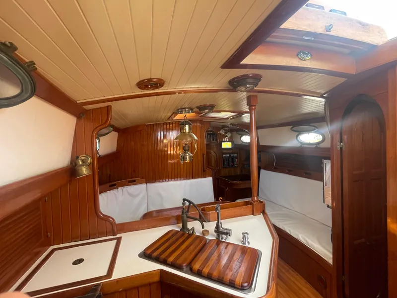 Slide: The Image of 1985 Hans Christian 33T yacht interior with wooden finishes and cozy seating area. - 17