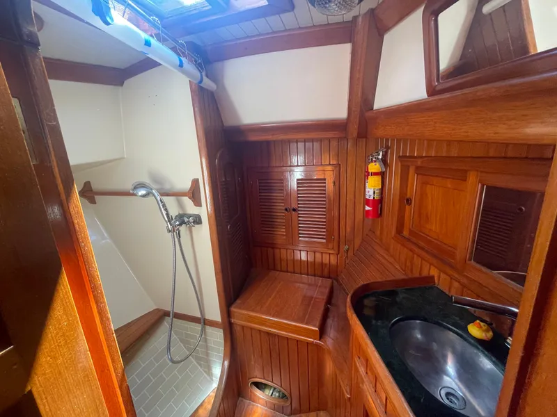 Slide: The Image of 1985 Hans Christian 33T yacht bathroom with wooden cabinetry, shower, and sink. - 21