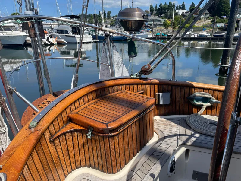 Slide: The Image of 1985 Hans Christian 33T sailboat cockpit with wooden details, docked in a marina. - 28
