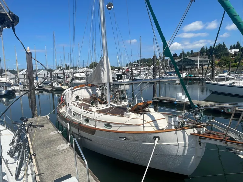 Slide: The Image of 1985 Hans Christian 33T sailboat docked in a marina under a clear blue sky. - 3