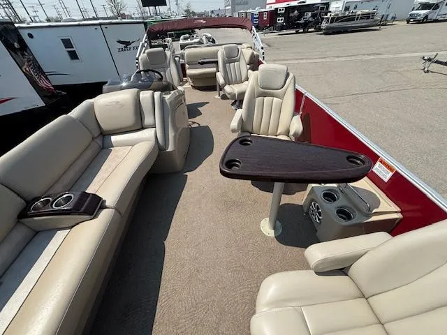Slide: The Image of 2012 Bennington R25 pontoon boat interior with beige seating and a central table. - 10