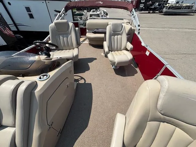 Slide: The Image of 2012 Bennington R25 pontoon boat interior with beige seating and red exterior. - 12
