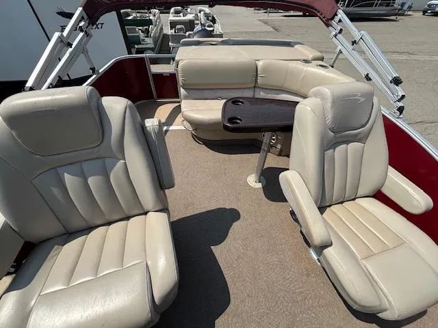 Slide: The Image of 2012 Bennington R25 boat interior with beige seating and a central table. - 14