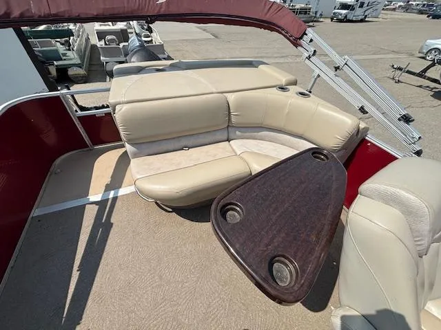 Slide: The Image of 2012 Bennington R25 boat interior with beige seating and wooden table. - 15