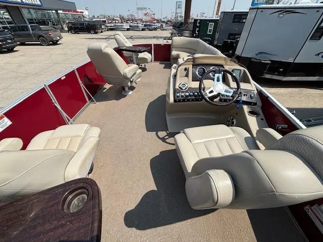 Slide: The Image of 2012 Bennington R25 pontoon boat interior with beige seating and steering console. - 20