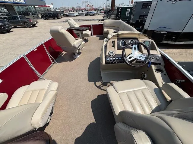 Slide: The Image of 2012 Bennington R25 pontoon boat interior with beige seating and steering console. - 22