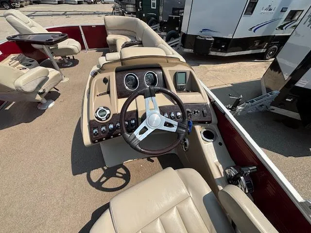 Slide: The Image of Interior view of a 2012 Bennington R25 boat with beige seating and steering console. - 23