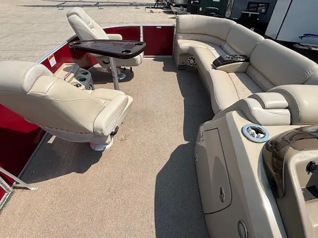 Slide: The Image of 2012 Bennington R25 pontoon boat interior with beige seating and a central table. - 30