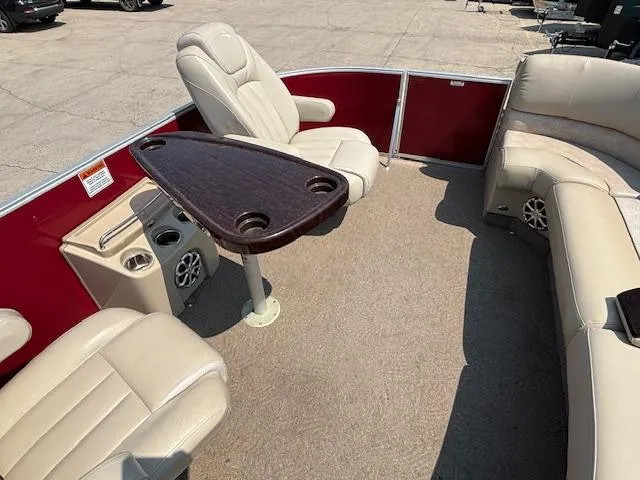 Slide: The Image of 2012 Bennington R25 boat interior with beige seating and a wooden table. - 32