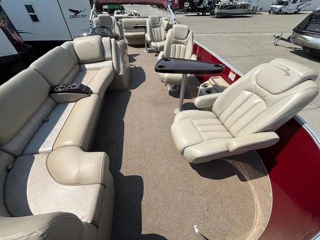 Slide: The Image of 2012 Bennington R25 pontoon boat interior with beige seating and table. - 9