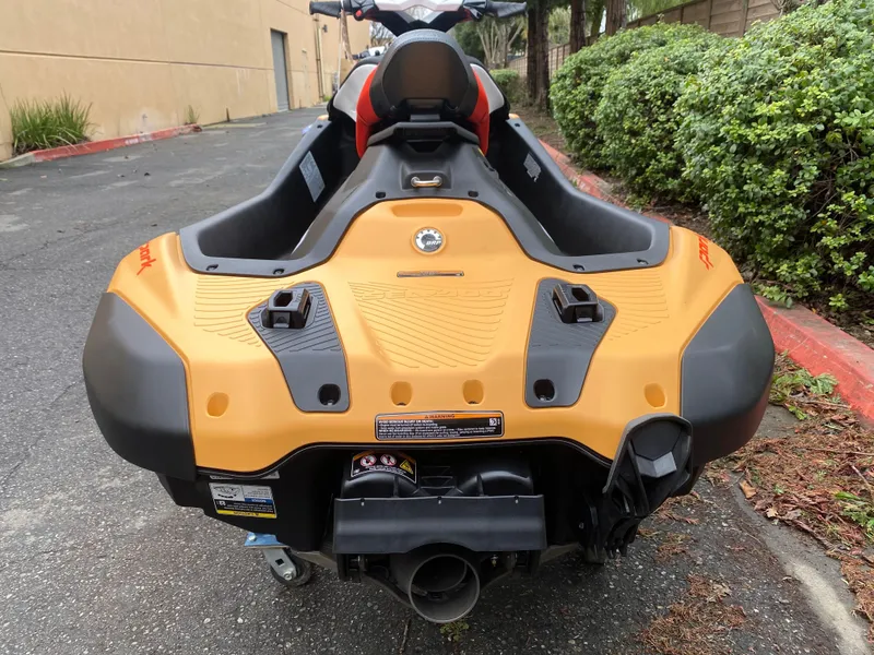Slide: The Image of 2024 Sea-Doo Spark 2up jet ski, rear view, parked on pavement. - 5