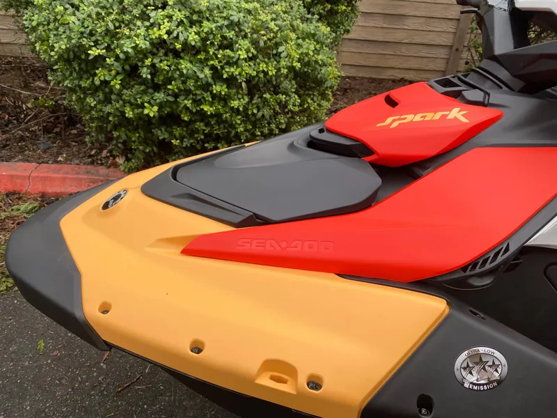 Slide: The Image of 2024 Sea-Doo Spark 2up jet ski, vibrant red and yellow design, parked outdoors. - 7