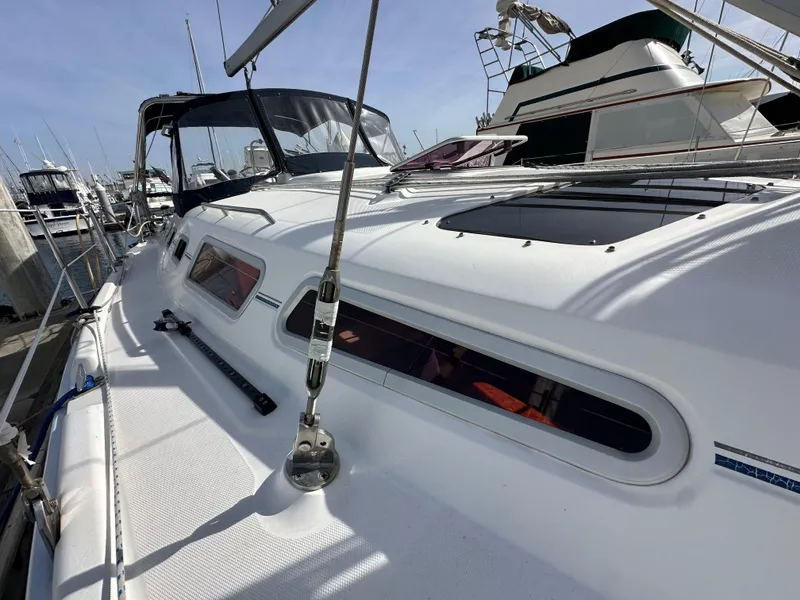 Slide: The Image of 2008 Hunter 38 sailboat docked at marina, showcasing sleek white deck design. - 17