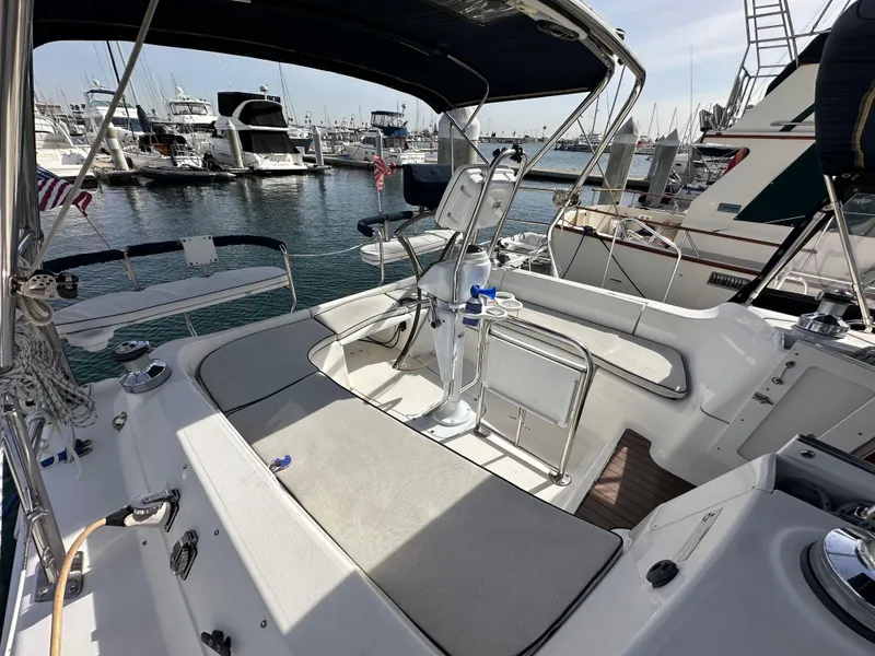 Slide: The Image of 2008 Hunter 38 sailboat cockpit with seating, steering wheel, and marina view. - 19