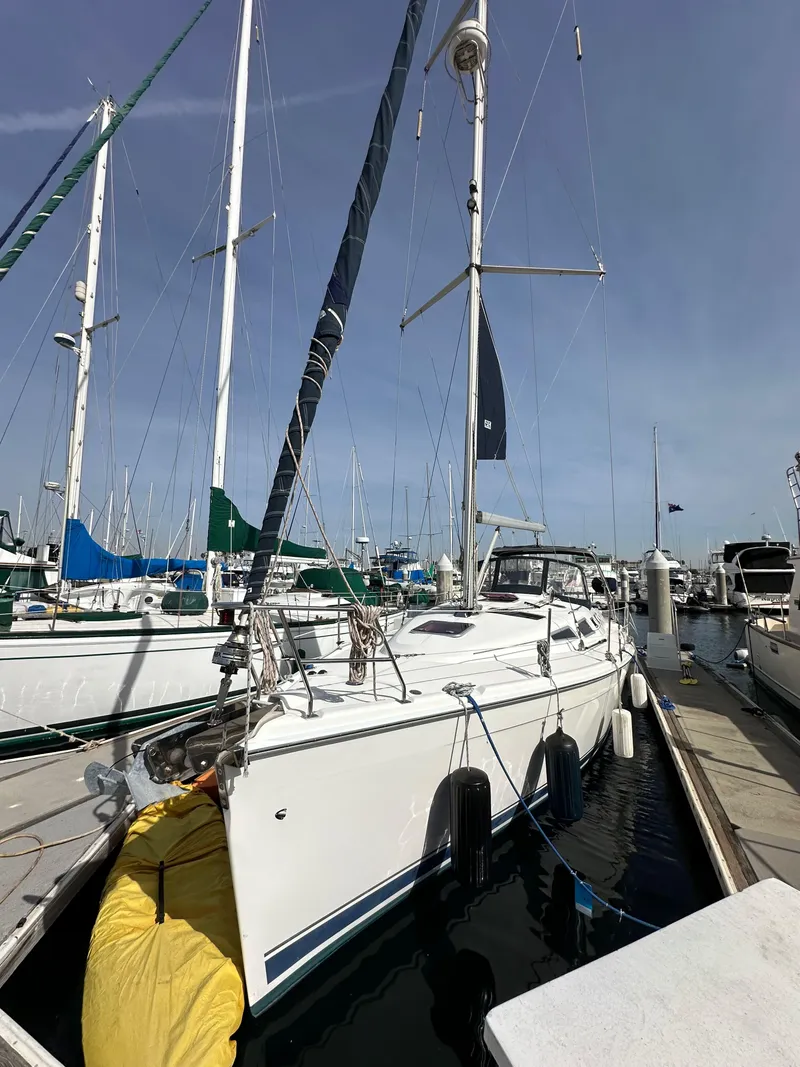 Slide: The Image of 2008 Hunter 38 sailboat docked at marina, surrounded by other boats. - 3