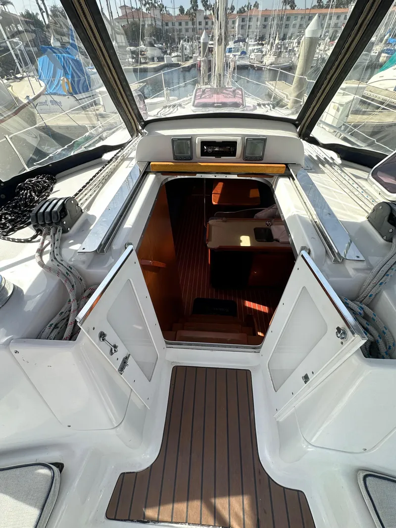 Slide: The Image of 2008 Hunter 38 sailboat cockpit with open cabin doors, docked at marina. - 37