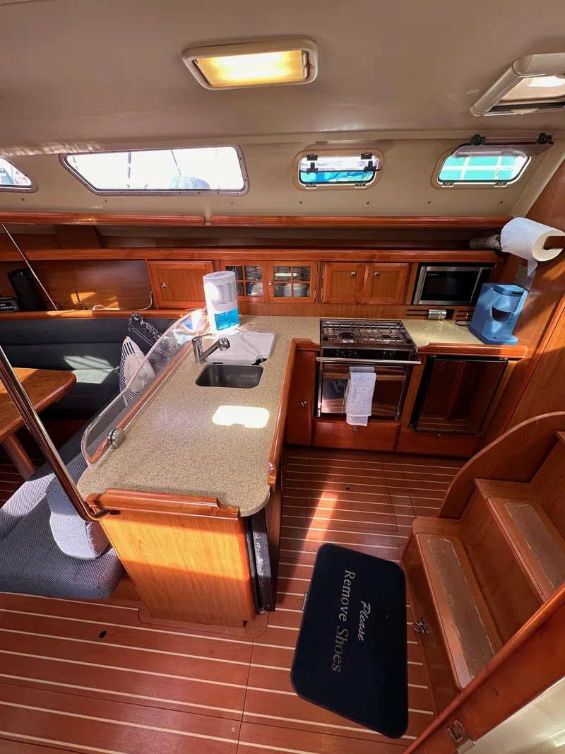 Slide: The Image of 2008 Hunter 38 yacht interior with kitchen, wooden cabinetry, and seating area. - 42