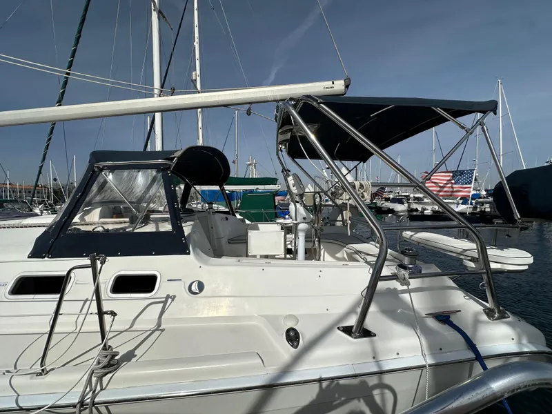 Slide: The Image of 2008 Hunter 38 sailboat docked in marina, featuring sleek design and canopy. - 9