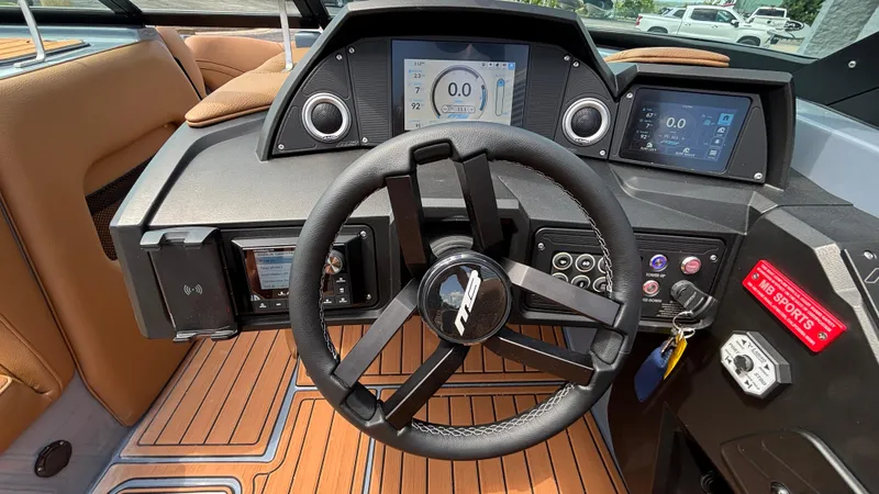 Slide: The Image of 2025 MB B52 23 Alpha boat dashboard with steering wheel and digital displays. - 24