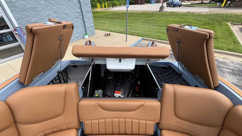 Slide: The Image of 2025 MB B52 23 Alpha boat interior with open storage compartments and tan seating. - 38