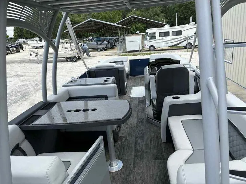 Slide: The Image of 2023 Godfrey AquaPatio 255 SDC pontoon boat interior with seating and table. - 12
