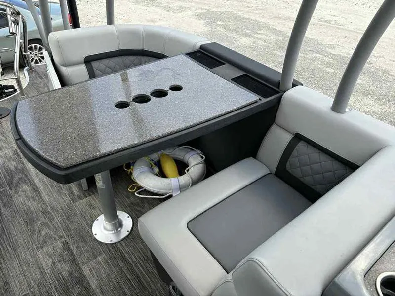 Slide: The Image of Luxurious seating area on 2023 Godfrey AquaPatio 255 SDC boat with sleek table design. - 14