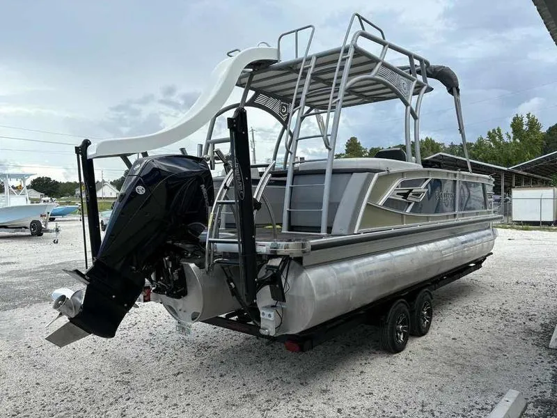 Slide: The Image of 2023 Godfrey AquaPatio 255 SDC pontoon boat with slide and outboard motor, parked on trailer. - 19