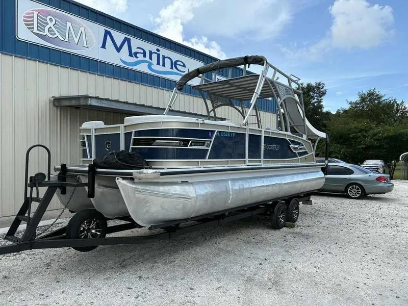 Slide: The Image of 2023 Godfrey AquaPatio 255 SDC pontoon boat on trailer at L&M Marine dealership. - 2