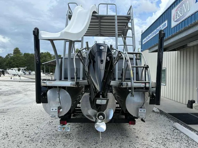 Slide: The Image of 2023 Godfrey AquaPatio 255 SDC pontoon boat with slide and outboard motor, parked outdoors. - 28