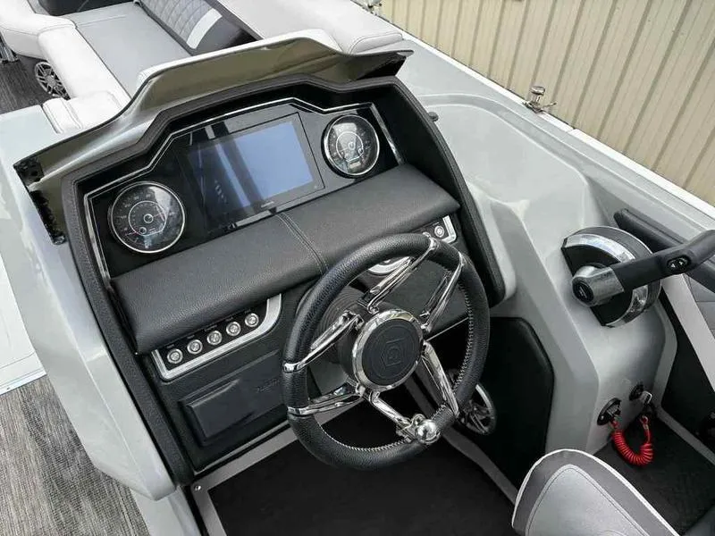 Slide: The Image of 2023 Godfrey AquaPatio 255 SDC boat dashboard with steering wheel and control panel. - 29