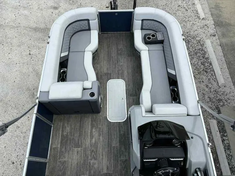 Slide: The Image of 2023 Godfrey AquaPatio 255 SDC pontoon boat interior with gray seating and wood-style flooring. - 4