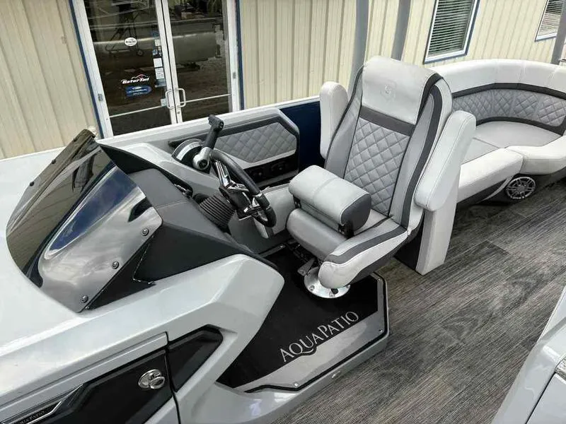 Slide: The Image of 2023 Godfrey AquaPatio 255 SDC boat interior with modern seating and steering console. - 6
