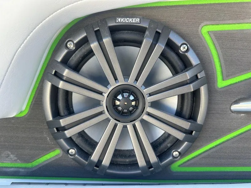 Slide: The Image of Kicker speaker in 2024 Tahoe 210 S boat with green accents. - 1