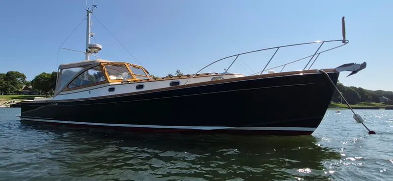 Slide: The Image of 1997 Able 44 Downeast Express Cruiser on calm water, showcasing sleek design and craftsmanship. - 2