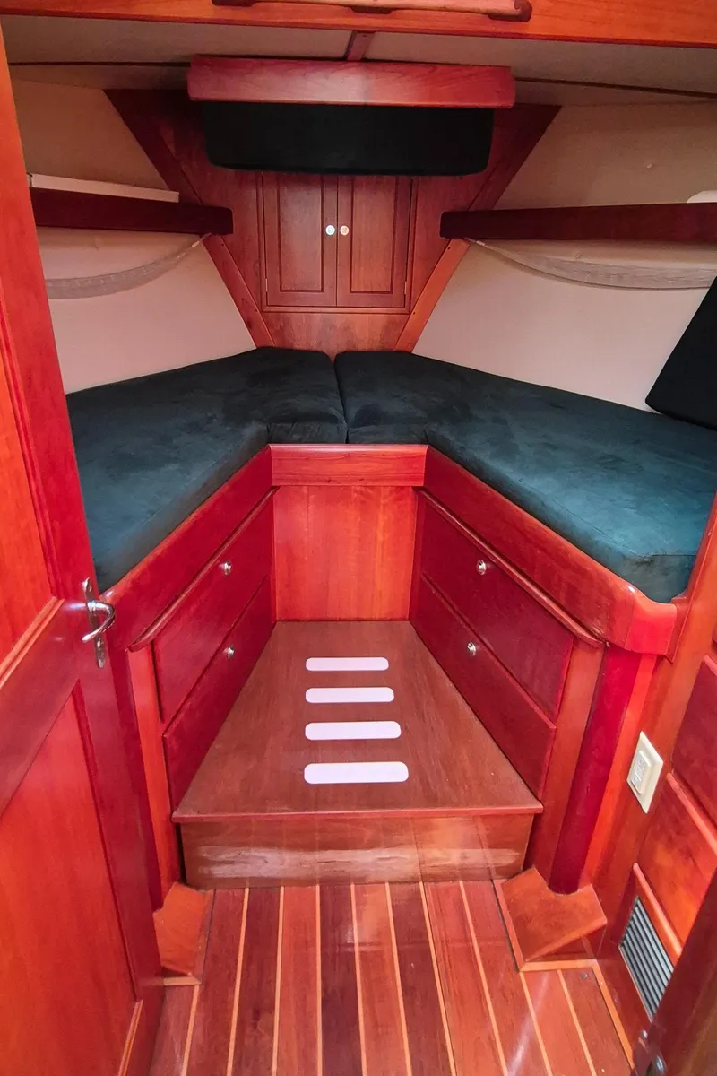 Slide: The Image of 1997 Able 44 Downeast Express Cruiser cabin with wood interior and cozy sleeping area. - 27