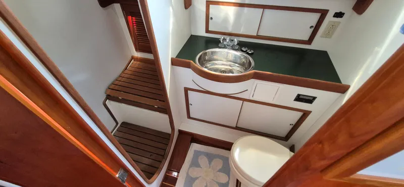 Slide: The Image of 1997 Able 44 Downeast Express Cruiser bathroom with wooden accents and stainless steel sink. - 34
