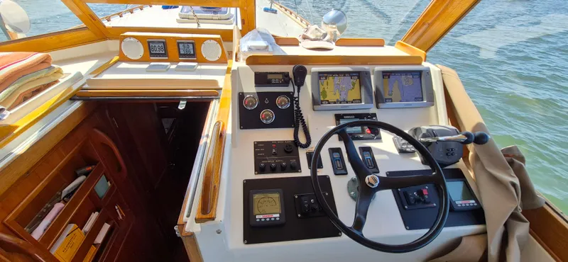 Slide: The Image of 1997 Able 44 Downeast Express Cruiser helm with navigation screens and controls on a sunny day. - 4