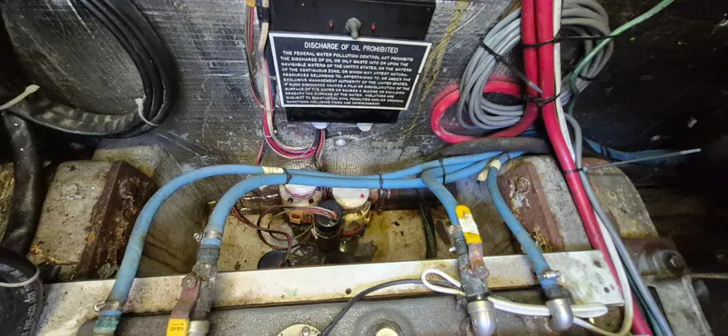 Slide: The Image of Engine compartment of 1997 Able 44 Downeast Express Cruiser with wiring and discharge warning sign. - 49