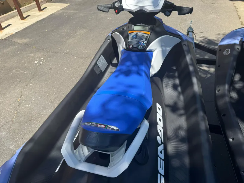 Slide: The Image of 2024 Sea-Doo Spark 2up jet ski with blue seat, parked on pavement. - 5