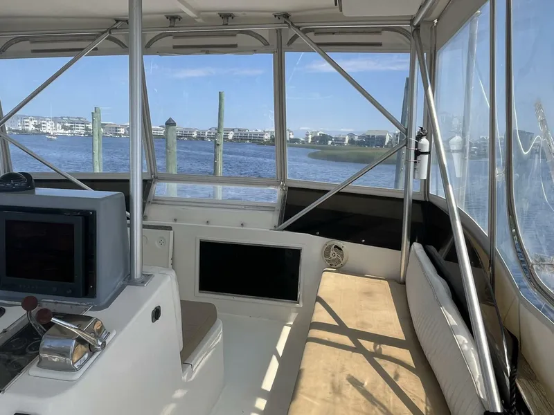 Slide: The Image of 1989 Topaz Sportfisherman boat interior with navigation equipment and waterfront view. - 10
