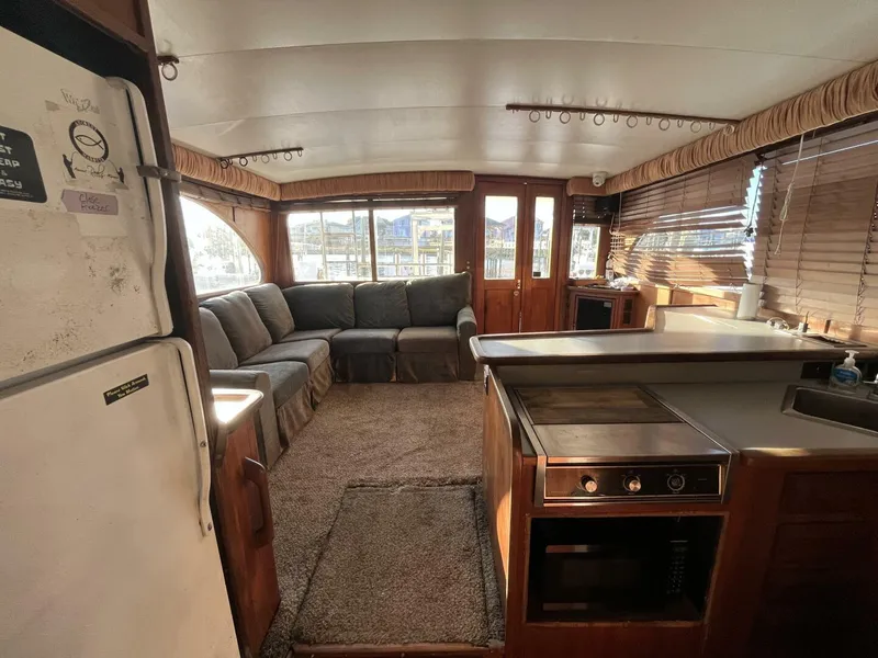 Slide: The Image of Interior of a 1989 Topaz Sportfisherman boat with cozy seating and kitchen area. - 13