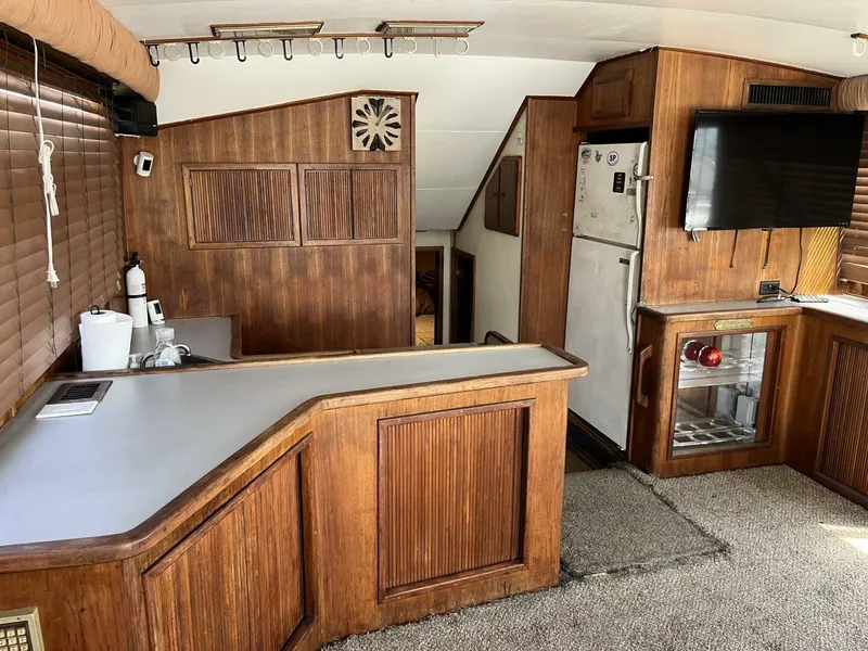 Slide: The Image of 1989 Topaz Sportfisherman interior with wood paneling, kitchenette, and TV. - 14