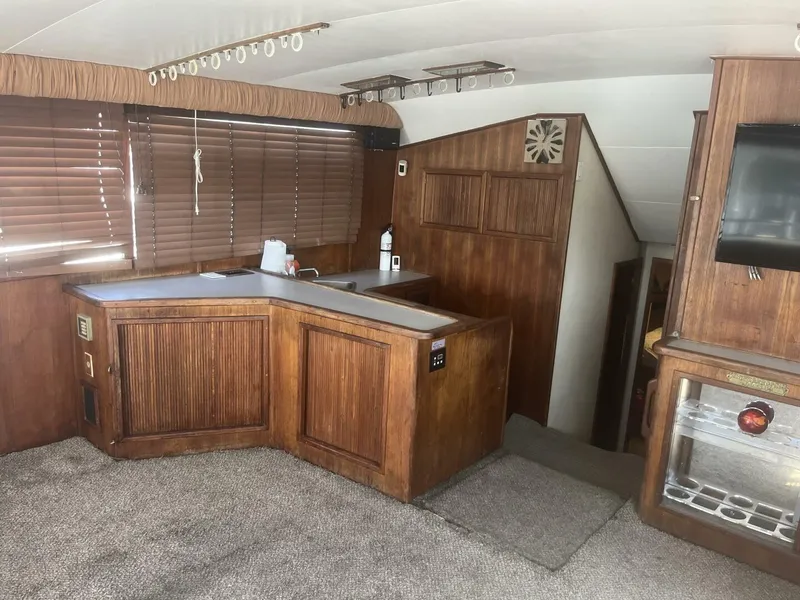 Slide: The Image of Interior of a 1989 Topaz Sportfisherman boat with wood paneling and carpeted flooring. - 15