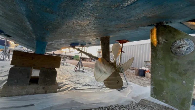 Slide: The Image of 1989 Topaz Sportfisherman boat underside with propeller and rudder in dry dock. - 20