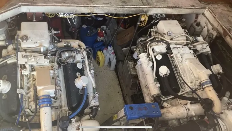 Slide: The Image of Engine room of a 1989 Topaz Sportfisherman boat with dual engines and maintenance supplies. - 22
