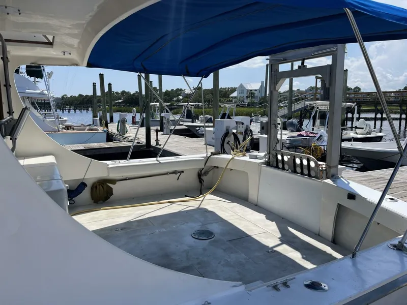 Slide: The Image of 1989 Topaz Sportfisherman boat with blue canopy docked at marina. - 5