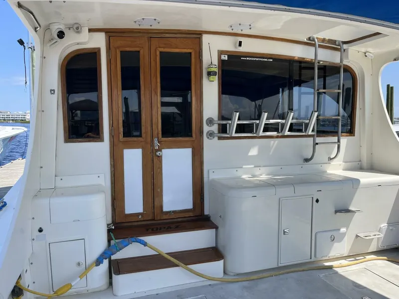 Slide: The Image of 1989 Topaz Sportfisherman boat interior with wooden doors and fishing rod holders. - 6