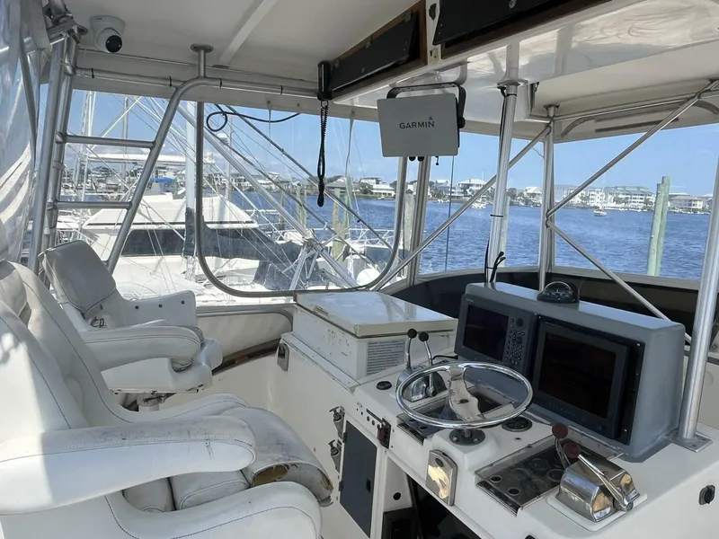 Slide: The Image of 1989 Topaz Sportfisherman boat cockpit with steering wheel, navigation equipment, and marina view. - 9