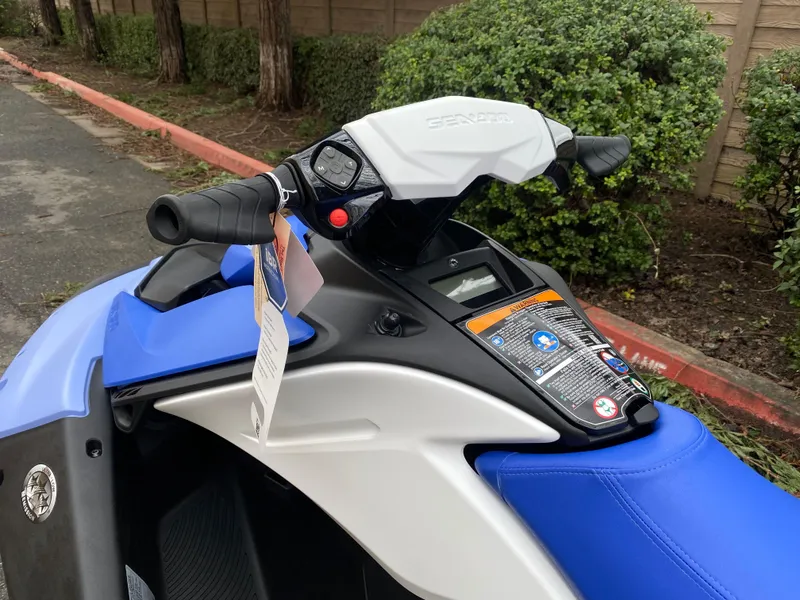 Slide: The Image of 2024 Sea-Doo Spark 3up jet ski with blue seat and handlebars, parked outdoors. - 4